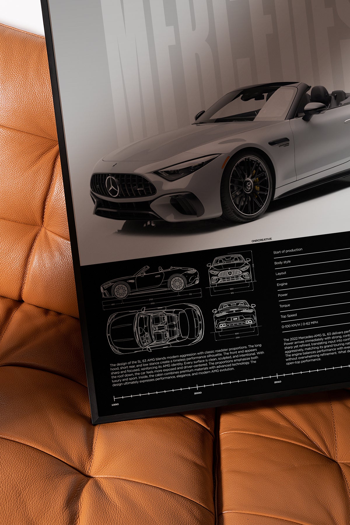 Framed Mercedes-AMG SL 63 R232 poster displayed on a brown leather chair, showing gray roadster artwork, blueprint details, and technical data section